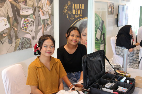 Indah (right) showing off her makeup and hairdo she did on her model (left).